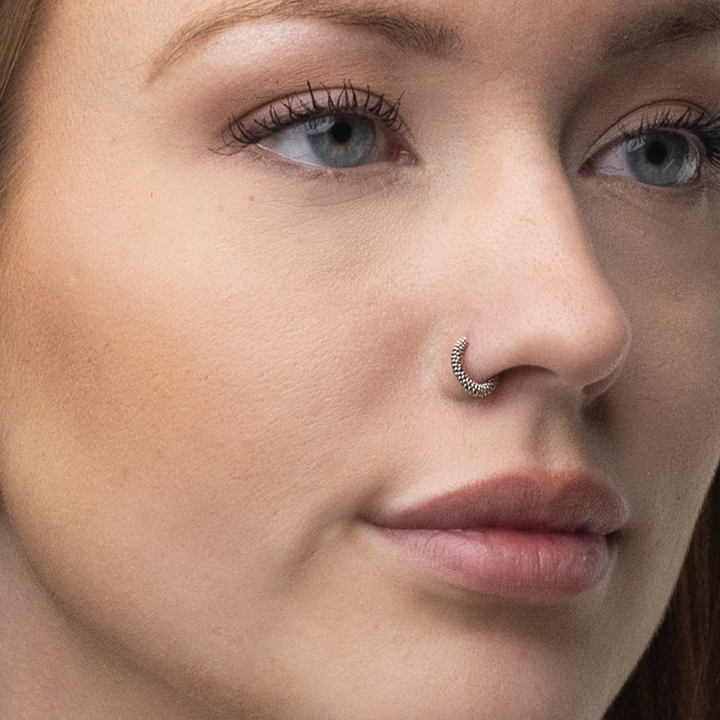 Näsring i silver, flätad med oxiderad yta